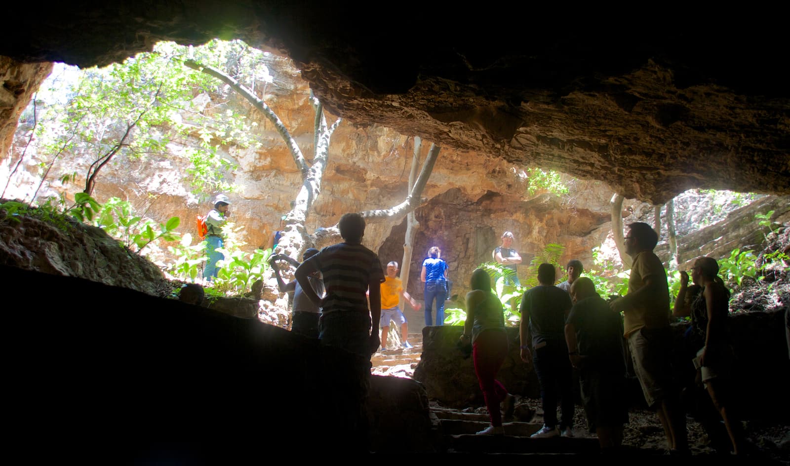 Visitors silhouetted against daylight inside the Sterkfontein Caves