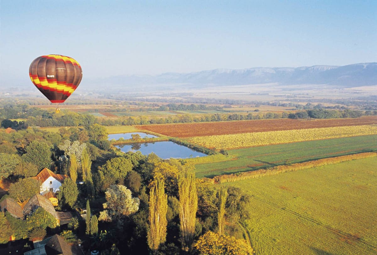 A hot-air balloon over the Magalies River valley in early morning light